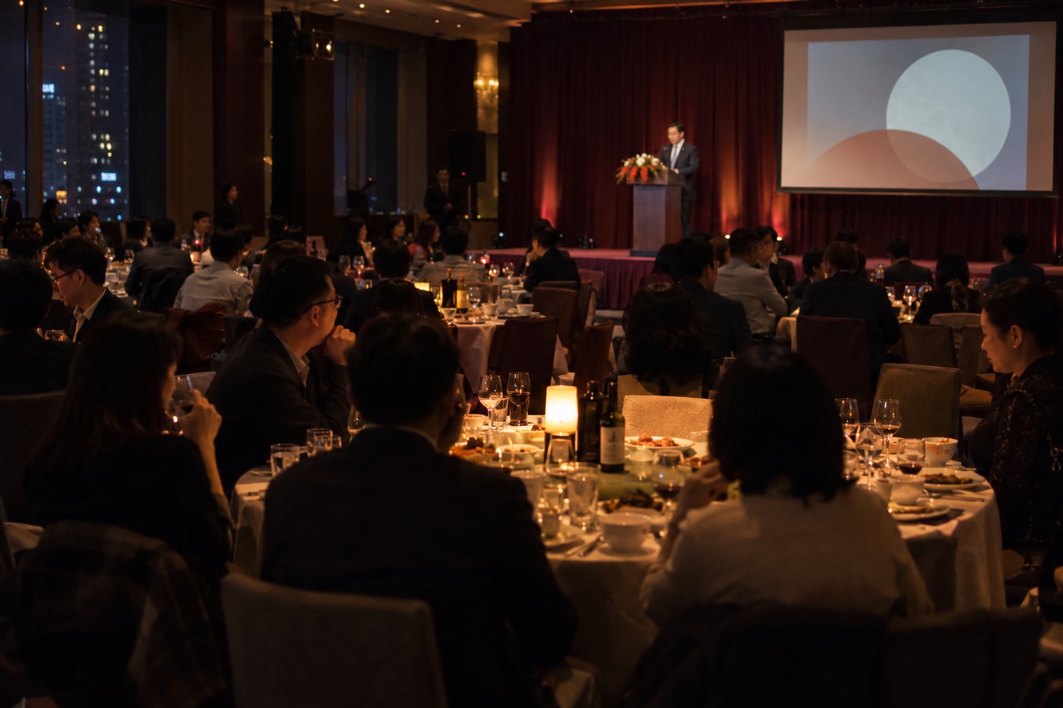 夜间企业年会，真实舞台灯光与来宾氛围示意
